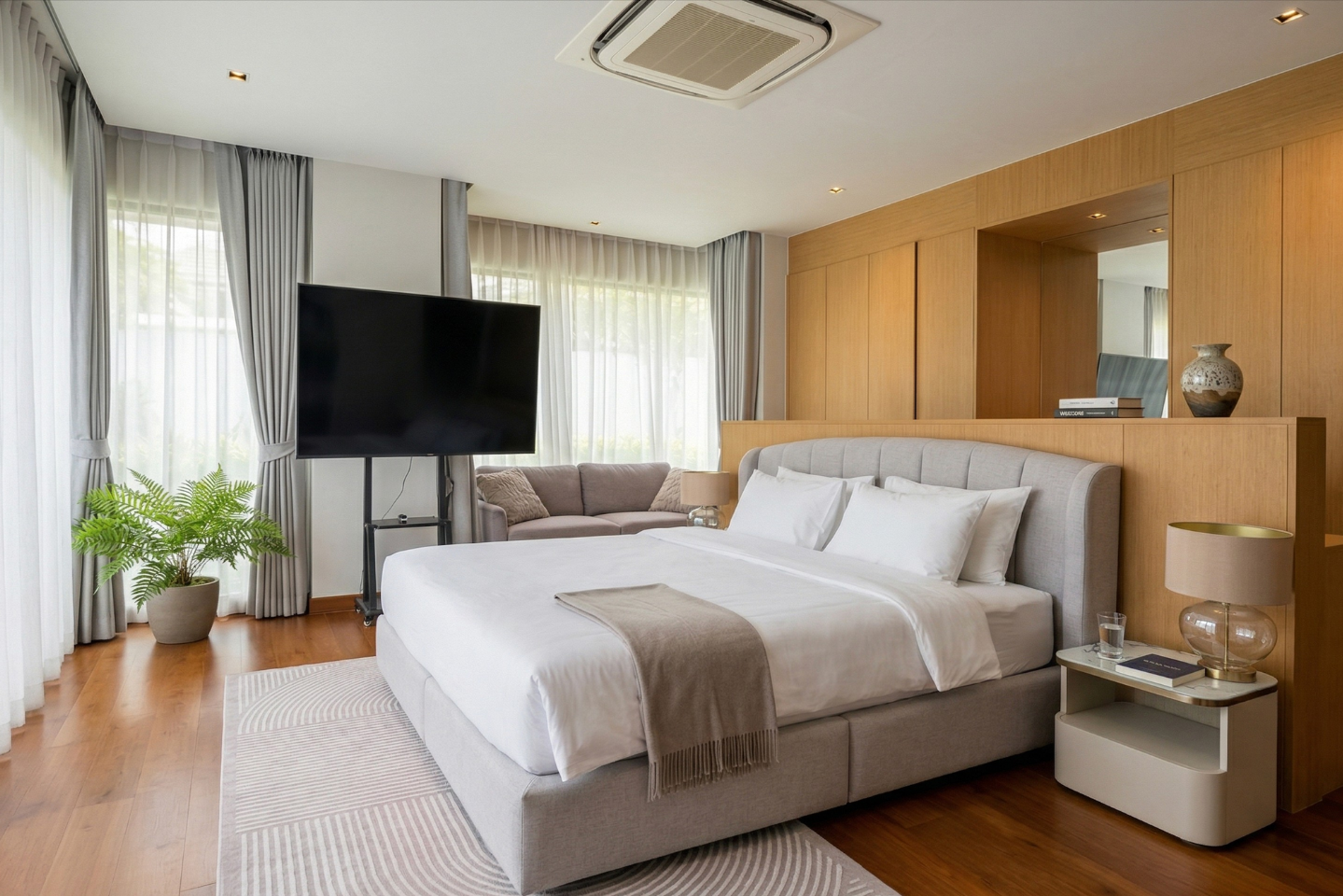 Villa Luma Botanica bedroom with king bed, wall-mounted TV and timber panelling