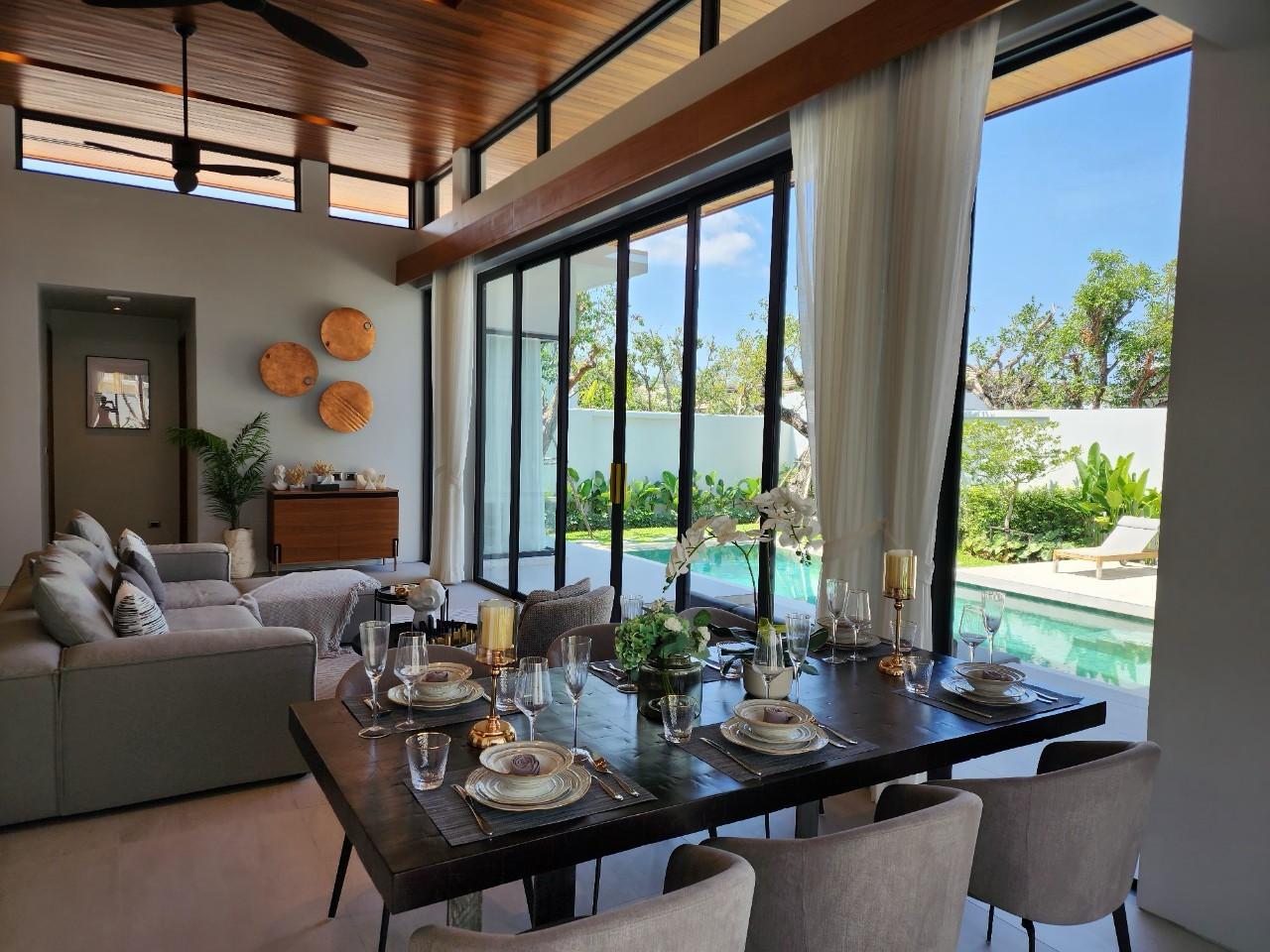 Villa Luma Botanica dining and living area with elegantly set table and poolside views through glass doors