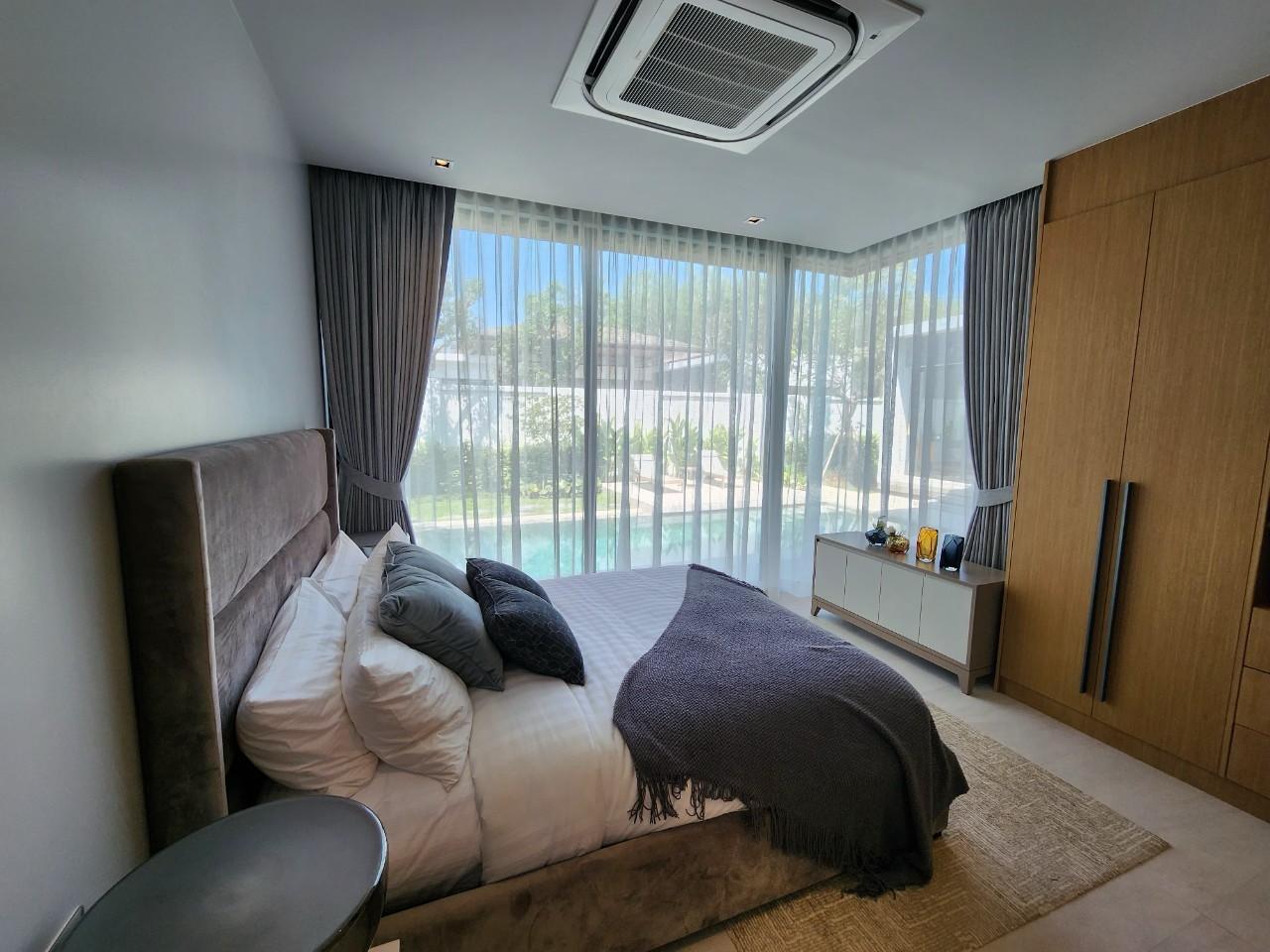 Villa Luma Botanica guest bedroom with plush bed, sheer curtains and pool views